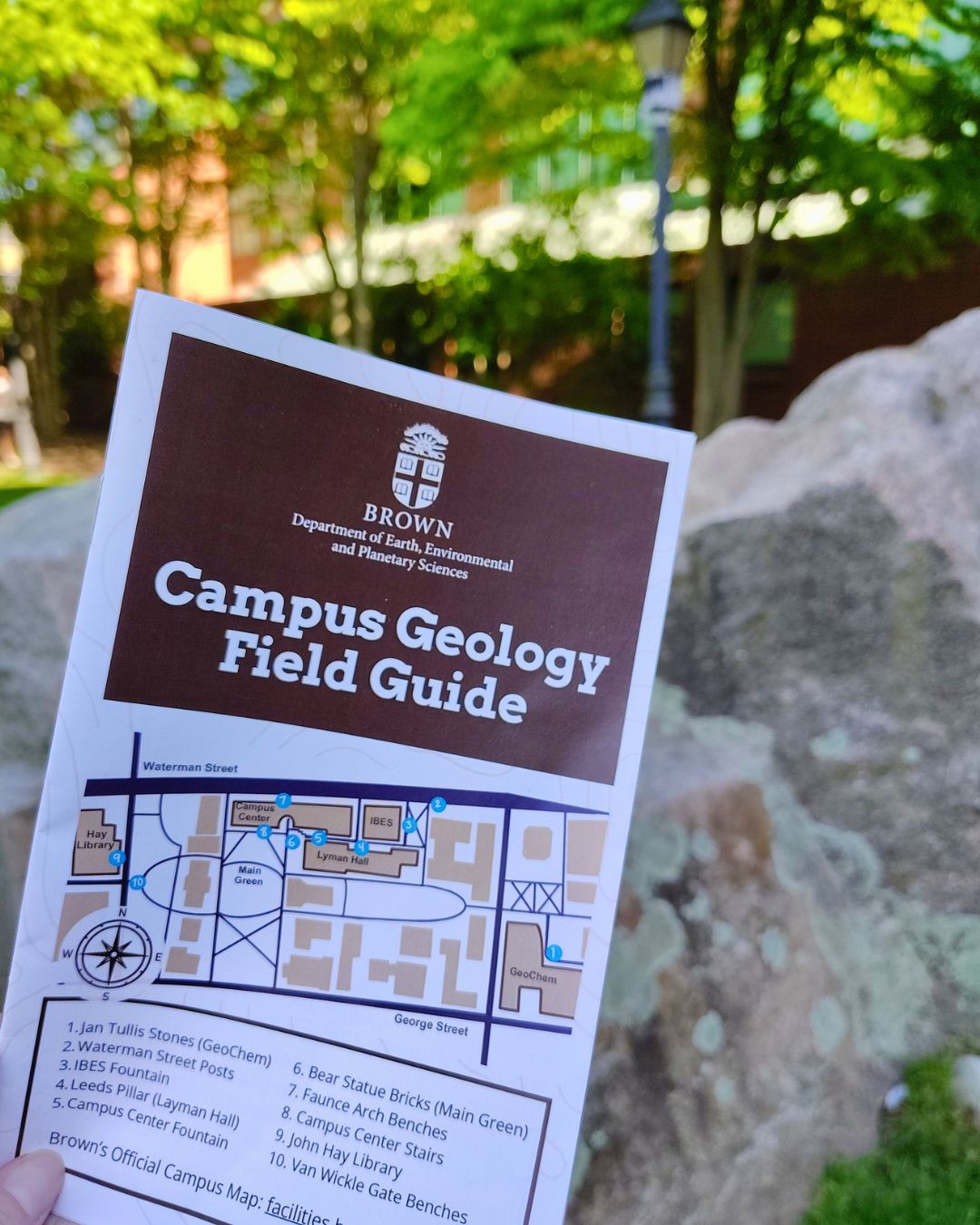 a copy of the Campus Geology Field Guide in front of the Jan Tullis stones