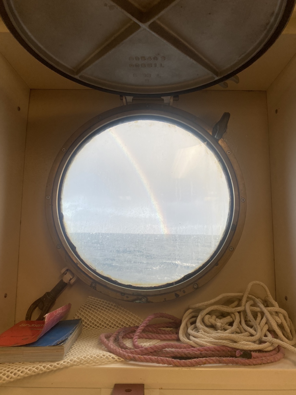 Rainbow through a porthole on the ship.