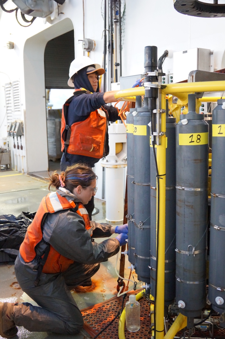 Élise Beaudin and Dante Capone (SIO) fill bottles with water from a CTD rosette, which the team used to collect water from below the sea surface 