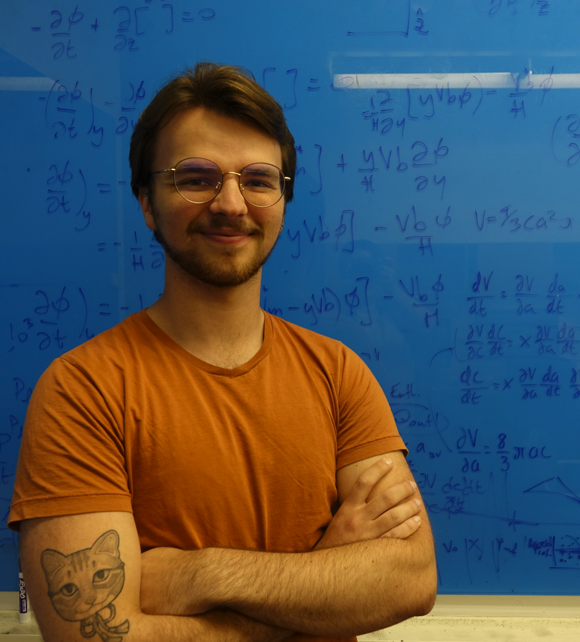 Gregorio posing in front of a whiteboard covered in calculations 