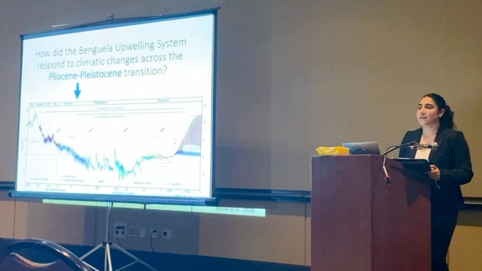 Student presenting her research at a podium.