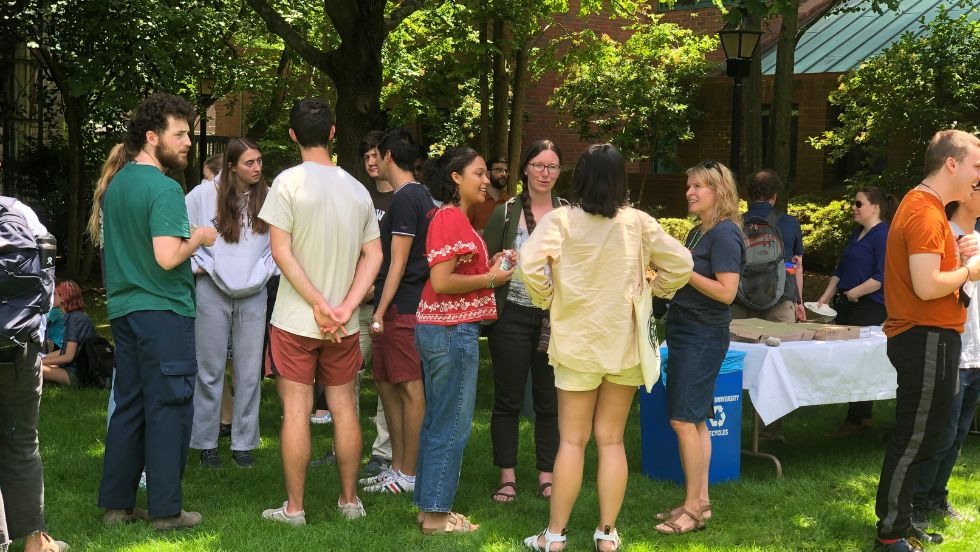 A group of students and faculty mingling at an outdoor picnic. 