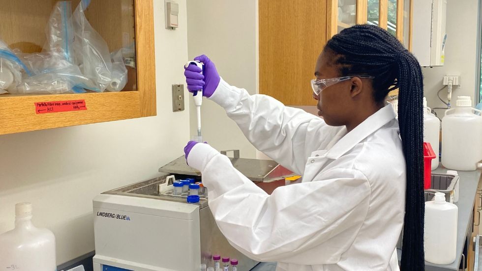 A student measuring liquid in a lab setting. 