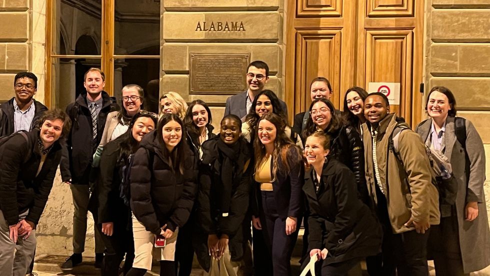 The large group of students standing for a photo outside the Alabama Arbitration Room in Geneva, Switzerland. 