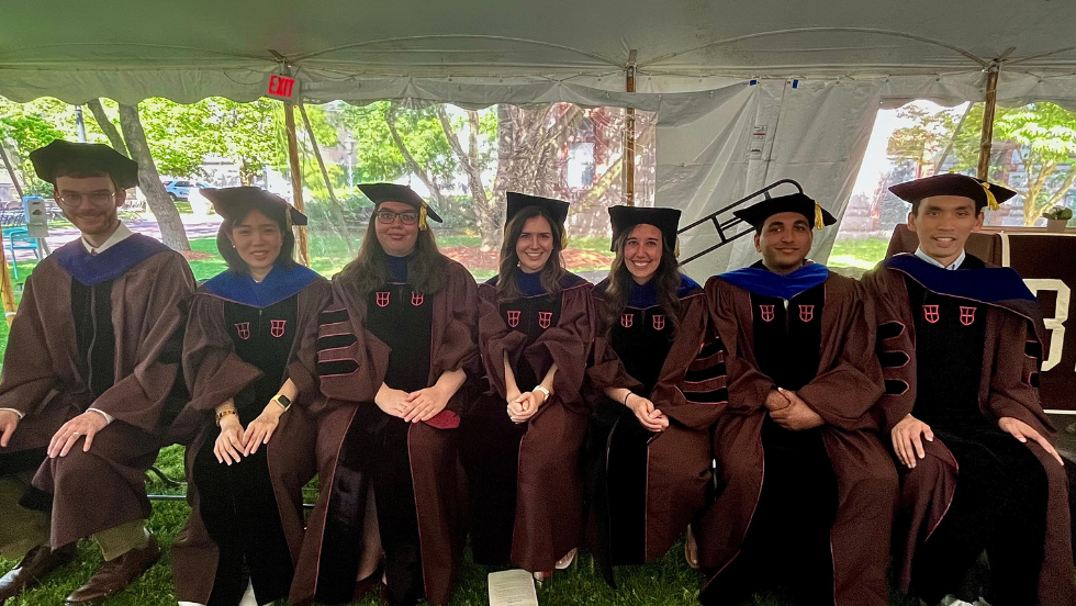 The PhD recipients smiling as a group at Commencement 