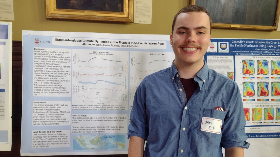 Alex Wilk stands in front of his research poster.