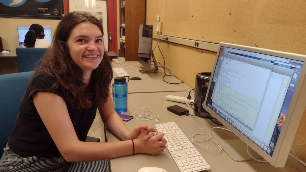 Anna smiling by her computer. 