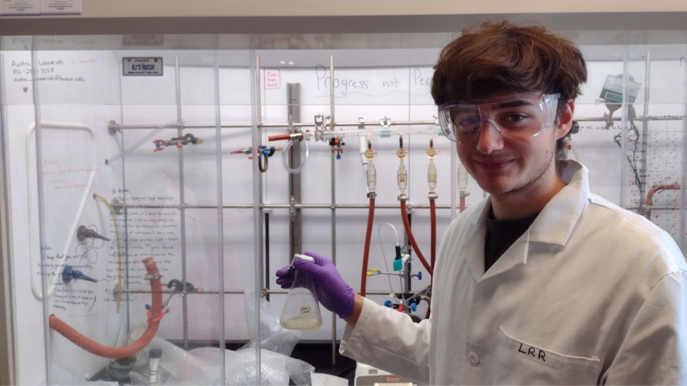 Luke holding a beaker in the chemistry lab. 