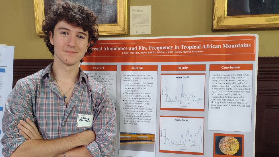 Charlie Madeiros standing in front of his research poster. 