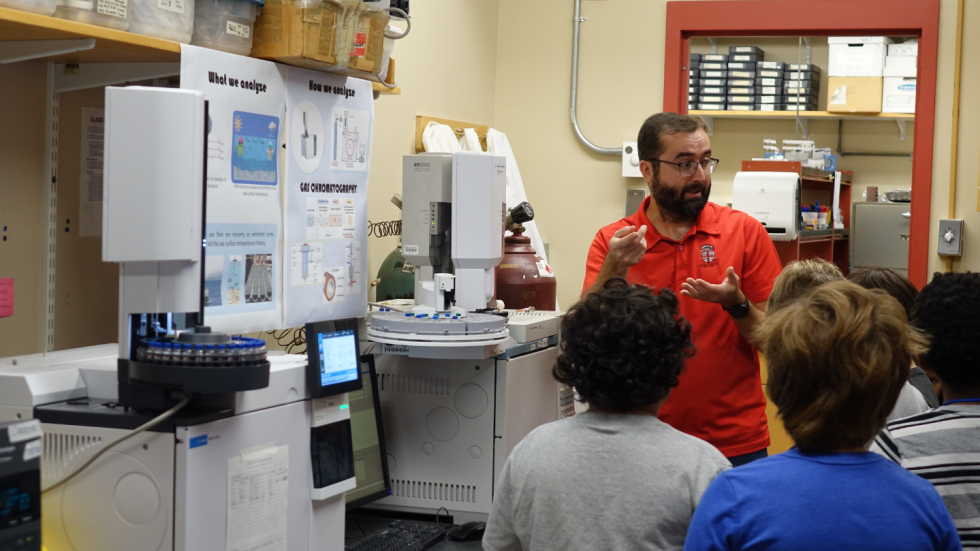 Marcelo Alexandre showing a group of 4th graders the specialized equipment in his lab.