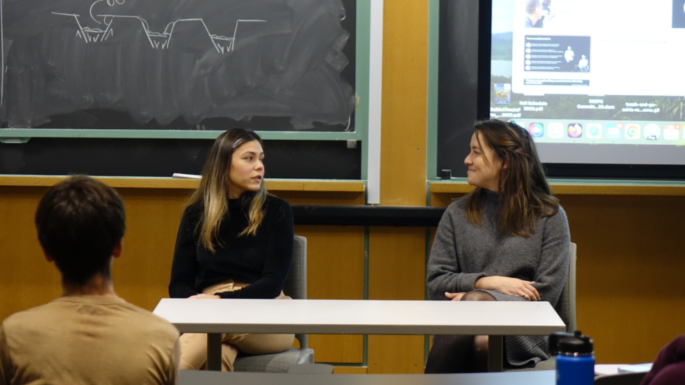 Isabella Gama Dantas and Mali'o Kodis sitting at the front of the room answering questions. 