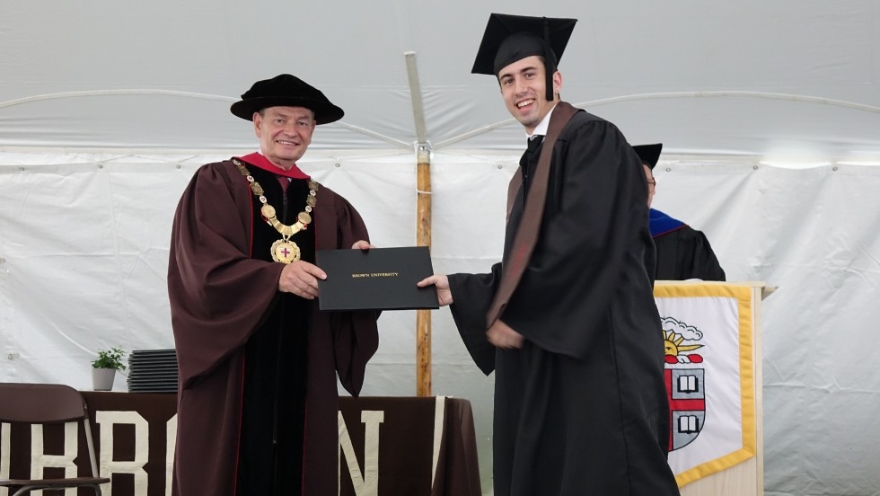 graduate receiving their diploma from Chancellor Samuel Mencoff