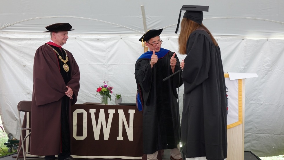 Greg Hirth gives two thumbs up to a graduating student