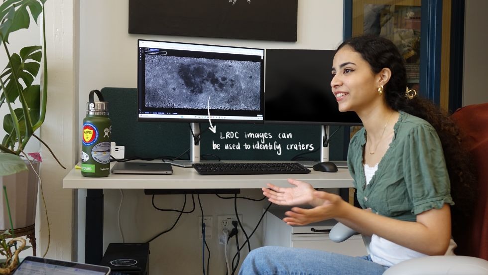 Sierra explaining her research on a computer