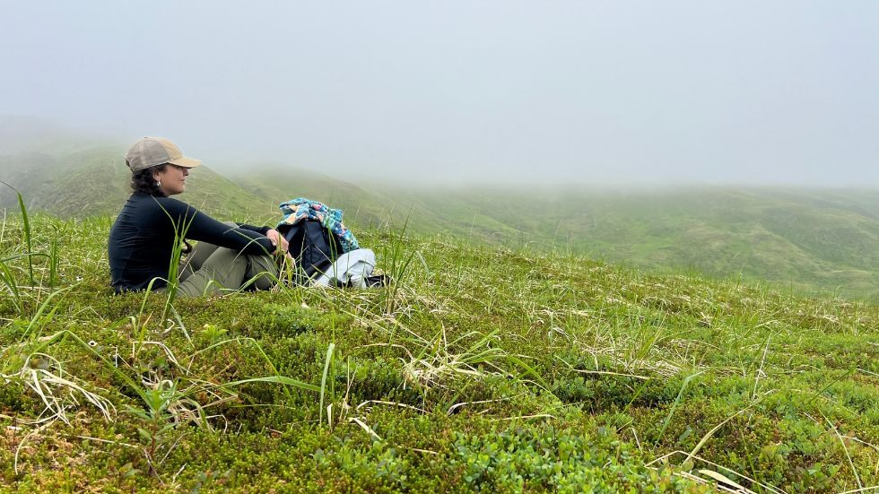 Anahi Carrera sitting in the grass and fog 