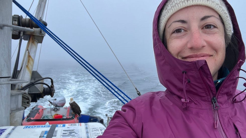 Emily Cooperdock on the boat with a bald eagle 