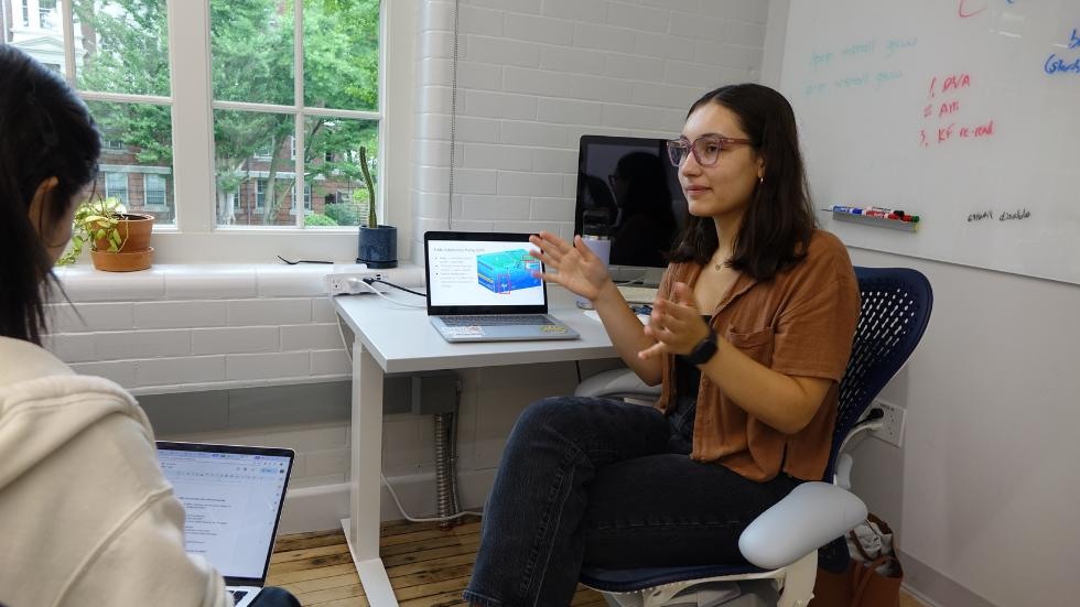 Margaret Gonzalez discussing her research with fellow student 