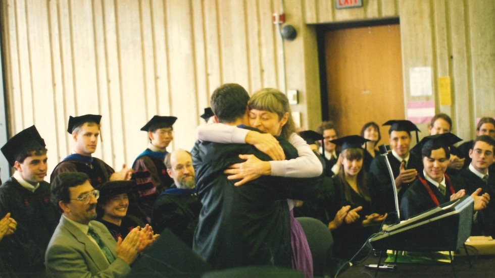 Jan hugging a student at graduation 