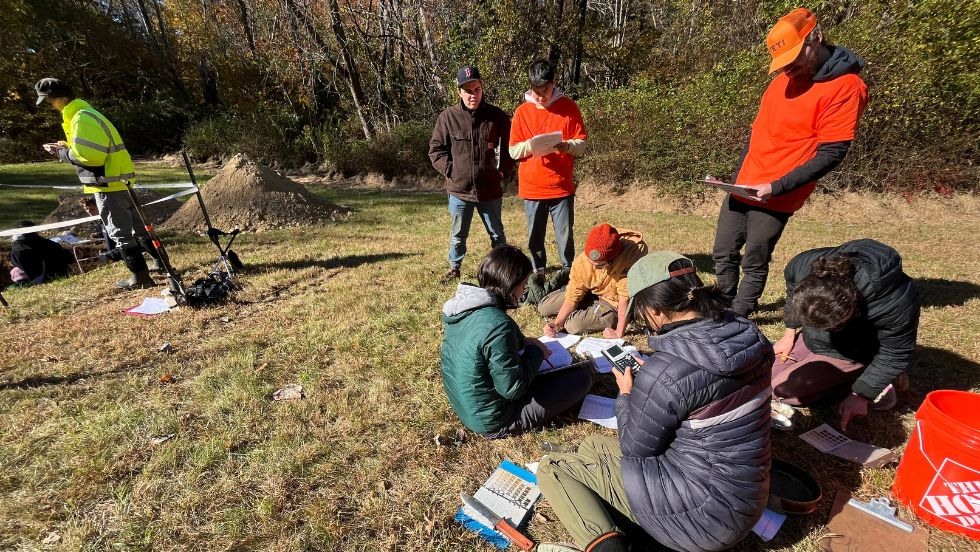 students gathered to review notes and make calculations on the grass