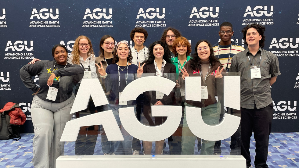 The 2024 REU students posing for a photo at the entrance of AGU Fall Meeting 2024