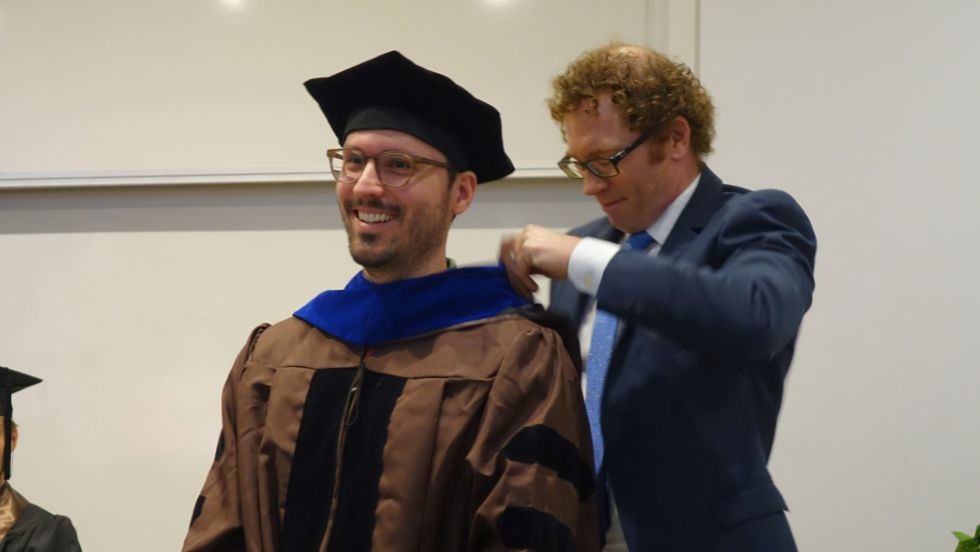 Prof Milliken bestowing graduate hood on Cody Schultz