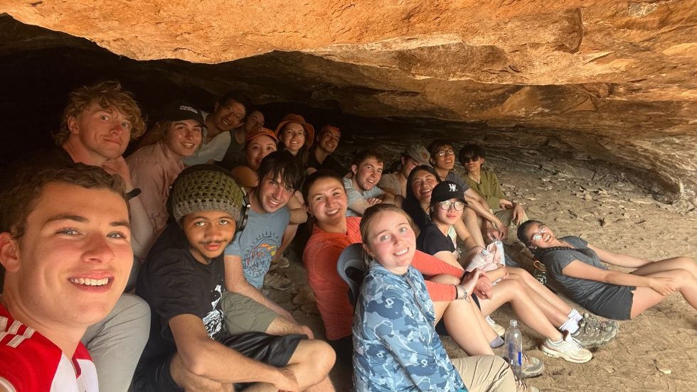 Students posing for a group selfie in a rock crevasse