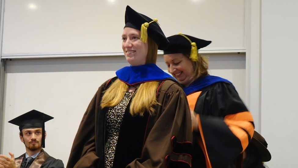 Chair Hastings bestowing graduate hood on Alexandra MacFarland