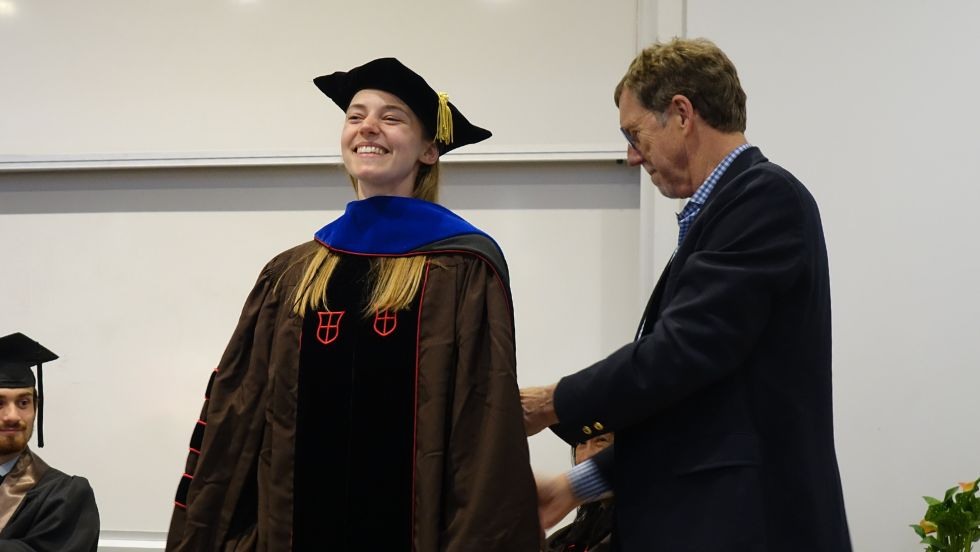 Prof Herbert bestowing graduate hood on Kristin Kimble