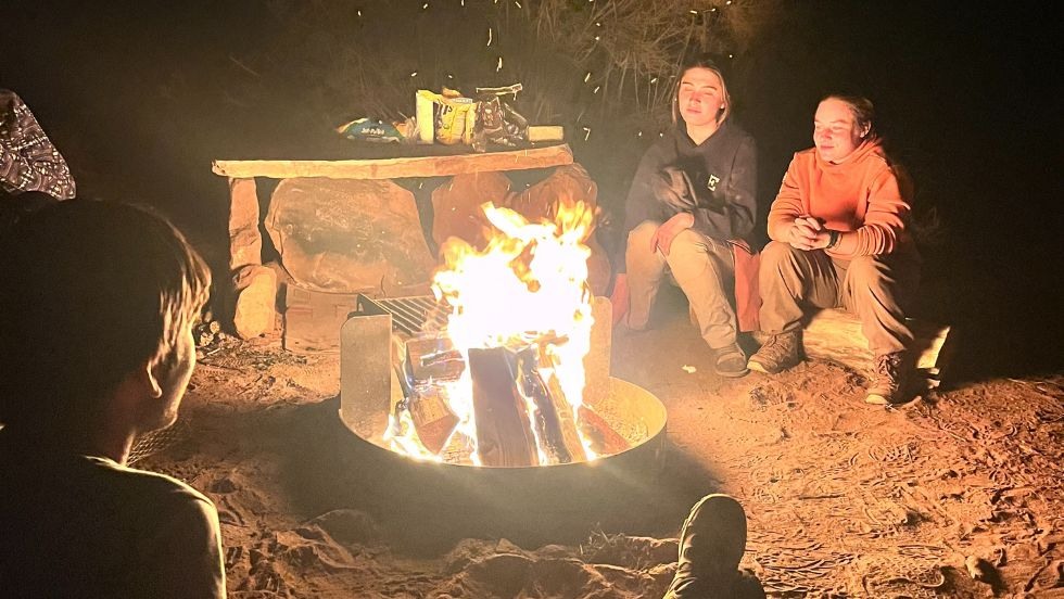 students sitting around a campfire