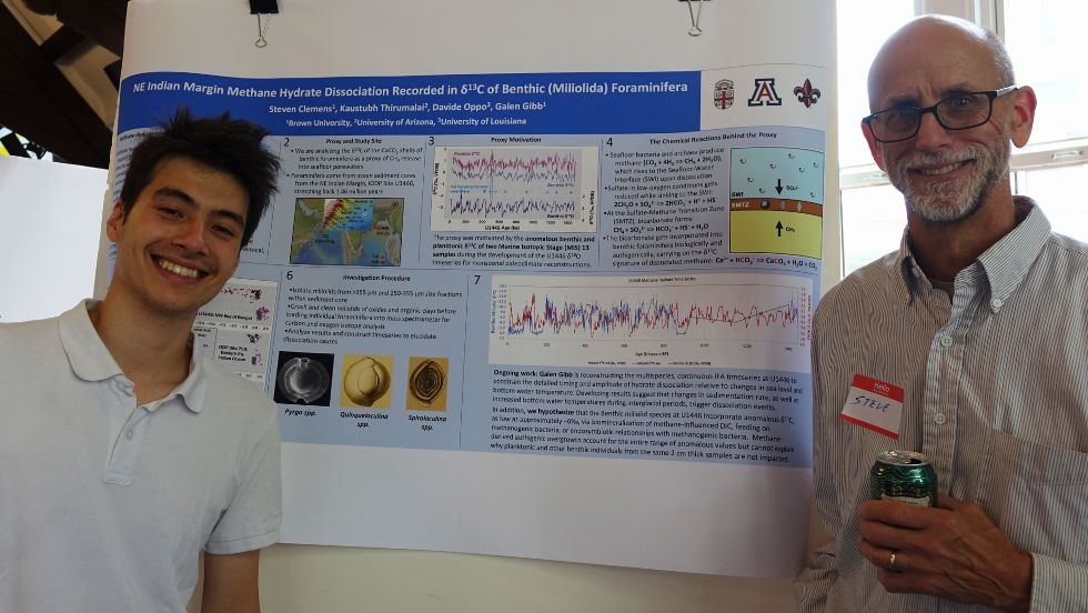 an undergrad student and faculty member smile in front of the student's research poster 