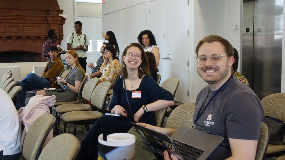 two attendees smile together between presentations 