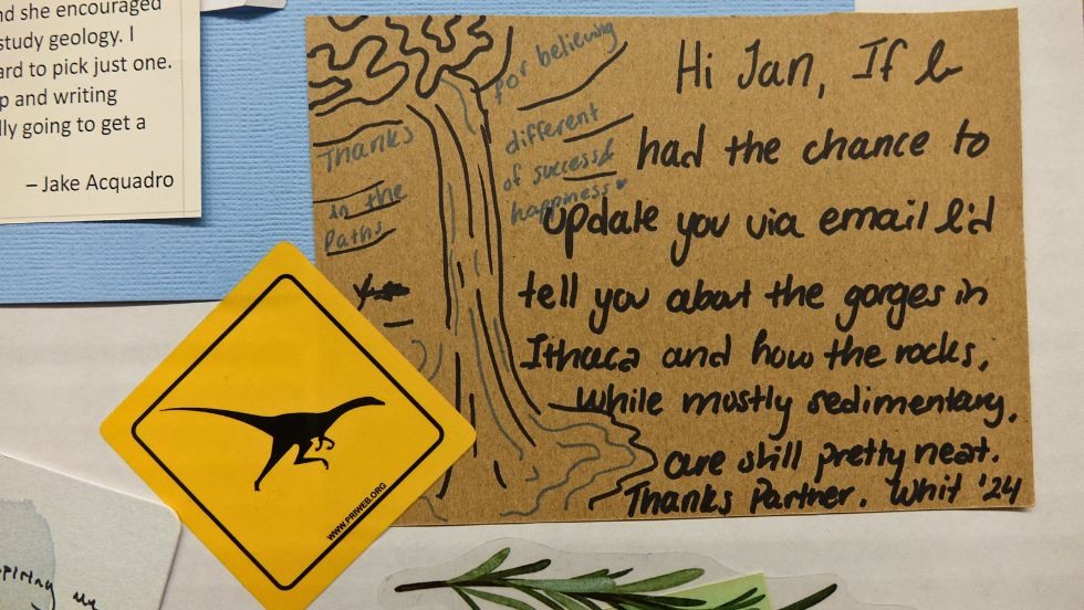 A closeup of a note and photos on the Jan memorial tapestry 