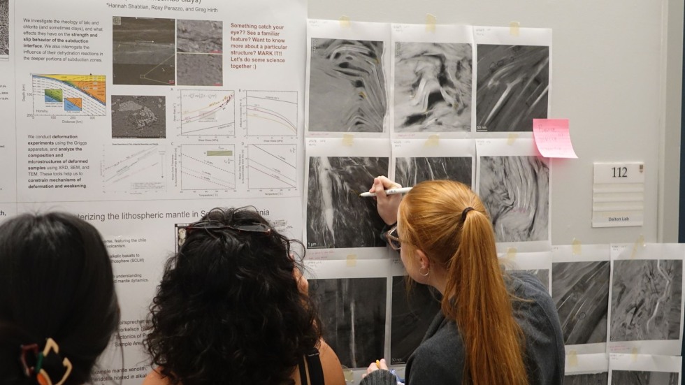 a grad student makes annotations on an interactive poster 