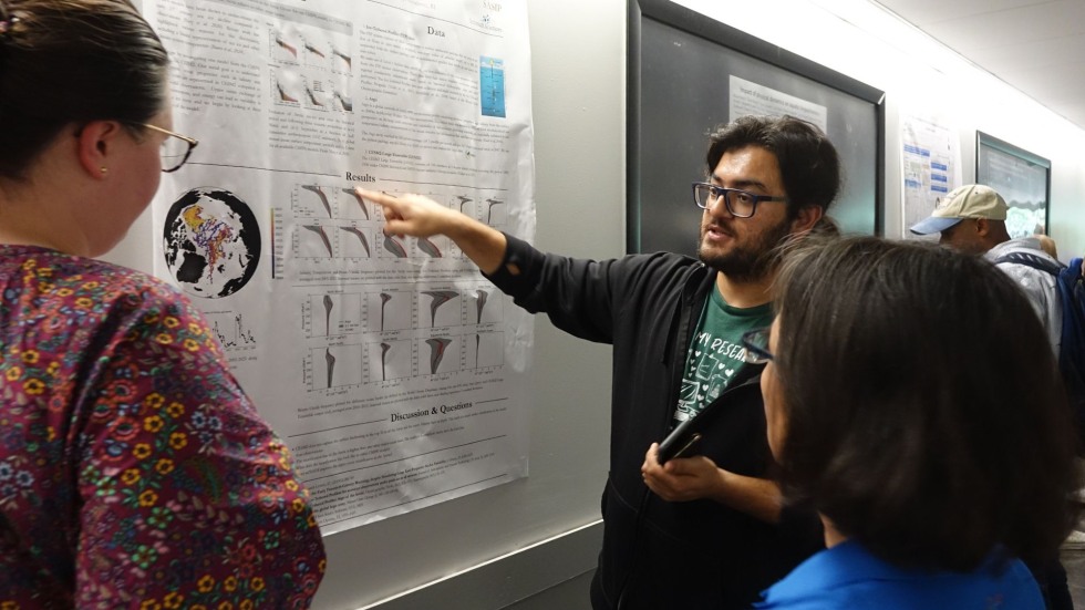 a postdoc pointing at his poster 