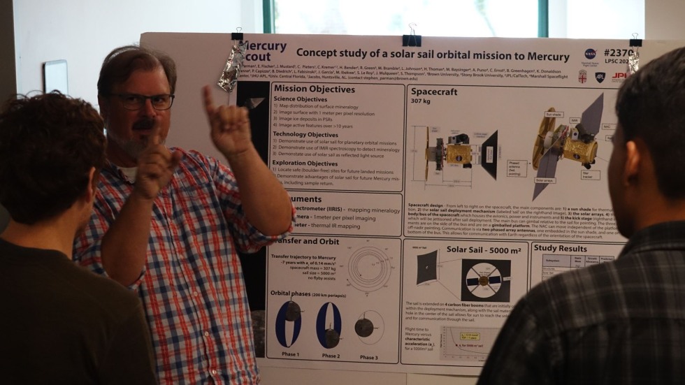 a faculty member discussing his poster 