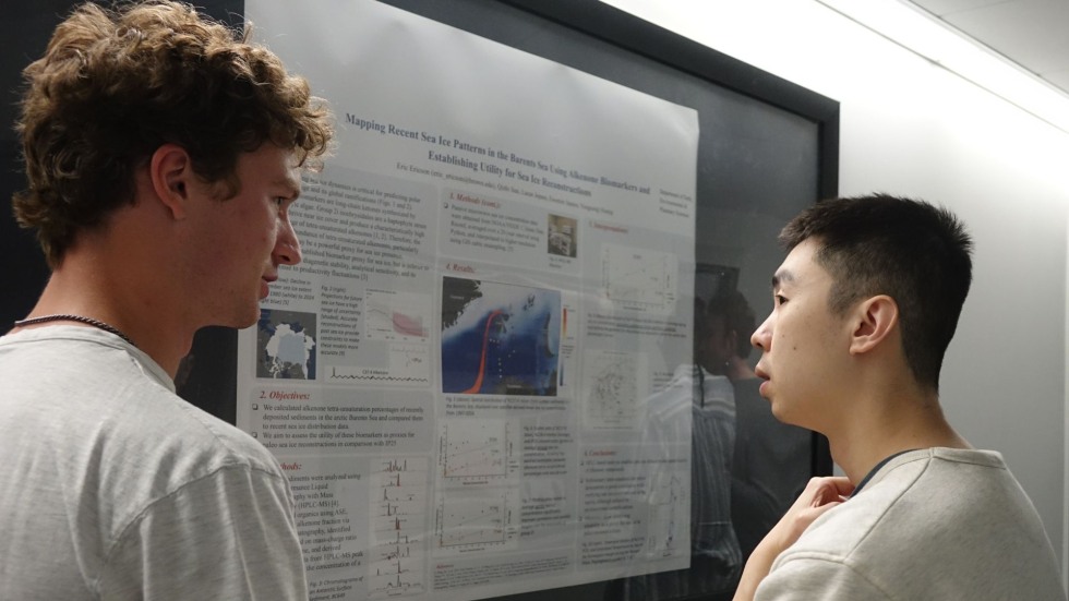 two students discuss a poster 