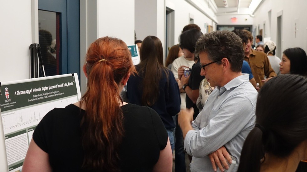 an undergrad student discusses her poster with a faculty member 