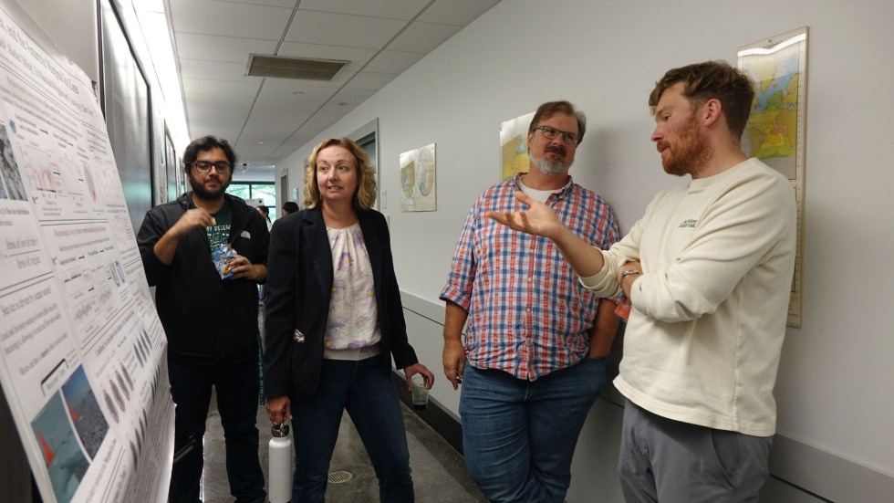 faculty members discussing a poster
