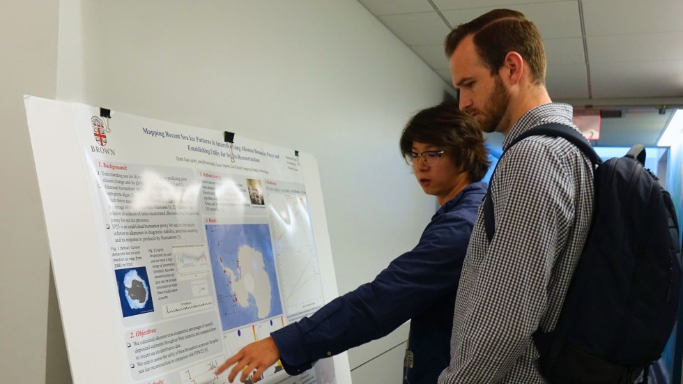 a student presenting his poster to a peer 