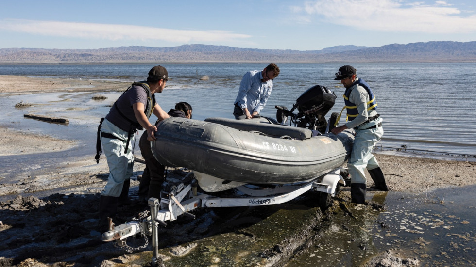 four scientists working together to launch a dingy into the salton sea
