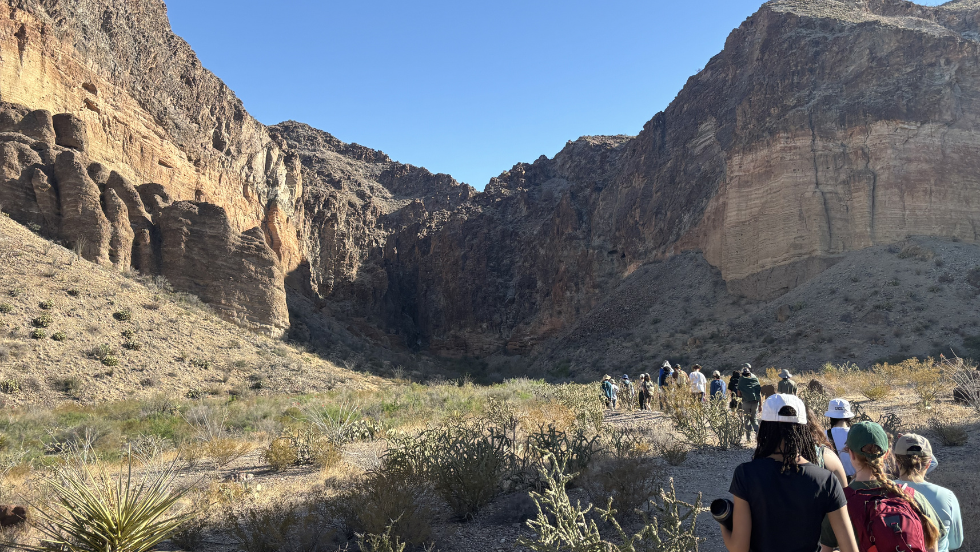students walking towards large stone cliffs in Texas