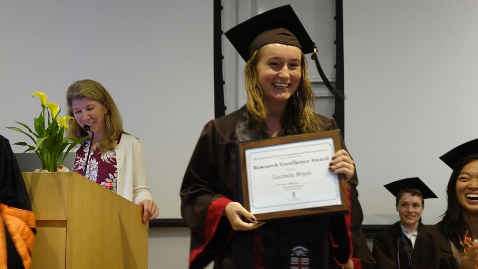 an undergrad smiles with her research award 