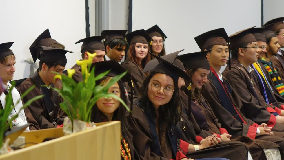 undergrads seated on stage, listening to the chair's speach 