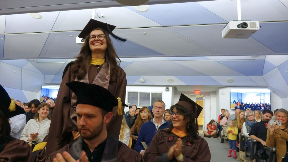 A ScM student stands smiling for her acknowledgements 