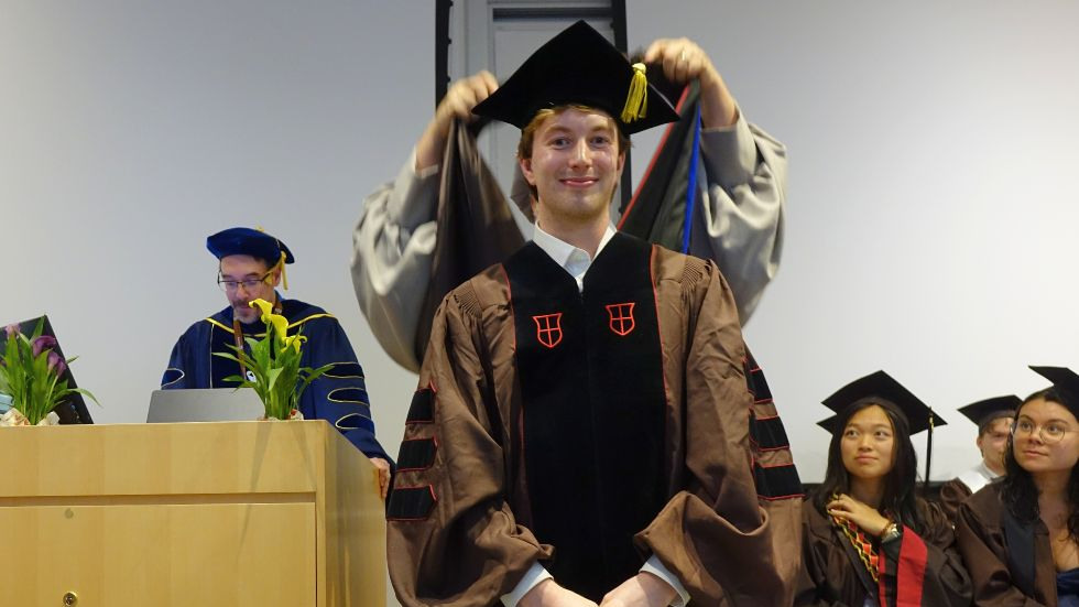 a PhD student receives his hood 