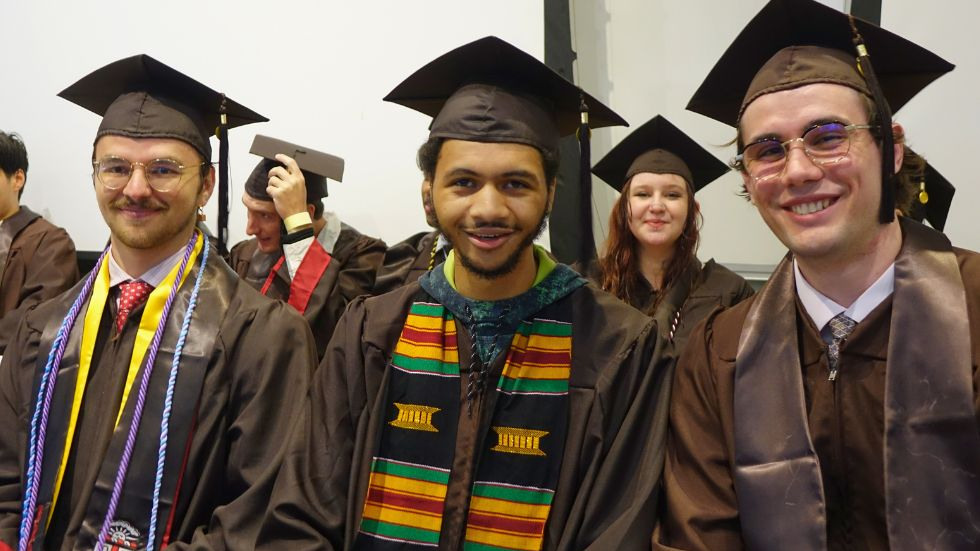 Undergrads smile together on stage just before the ceremony 