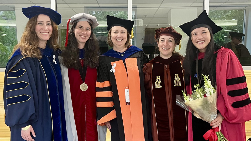 five professors smile together in regalia 