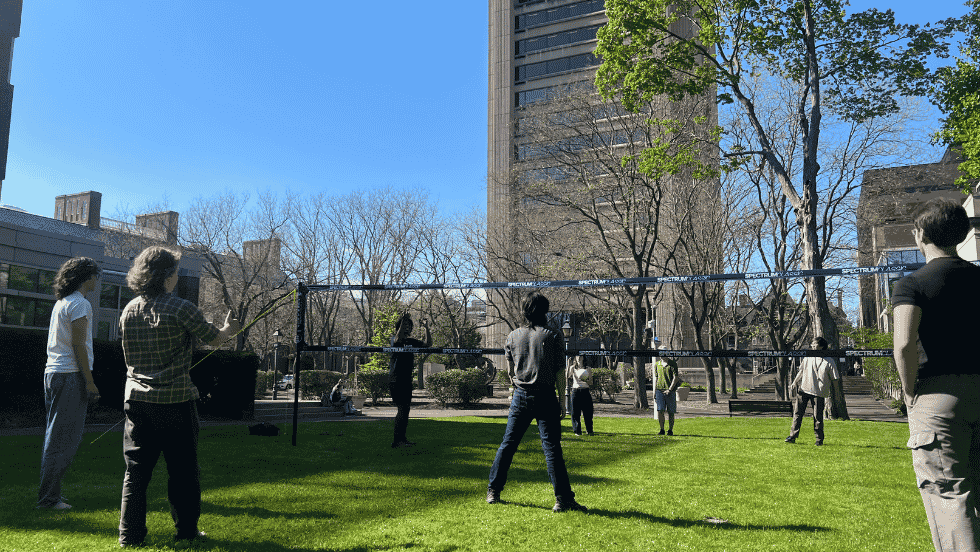 students playing volleyball on the Macmillan green on a beautiful day