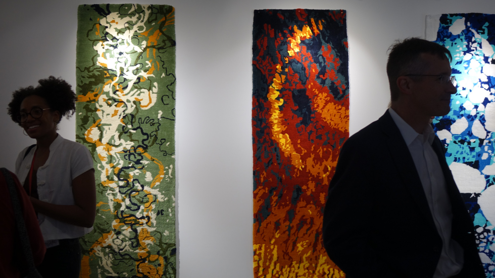 guests mingling in front of the FOLIATION tapestries 