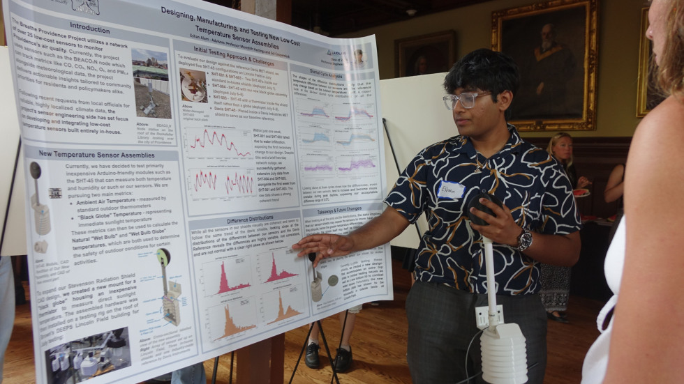 Eshan Alam speaking to someone out of view about his poster 